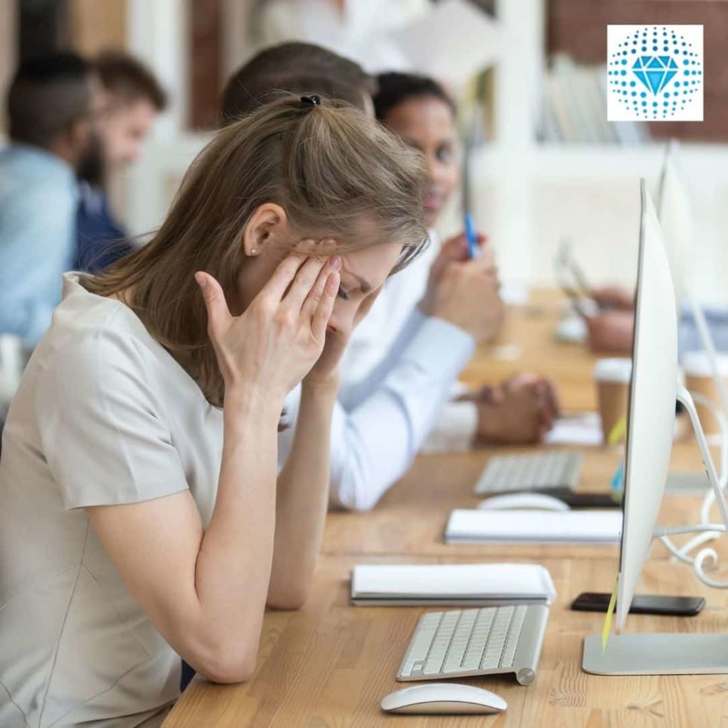 woman rubbing temples at desk workplace health and safety