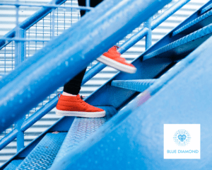 person climbing steps in bright red shoes with blue diamond logo