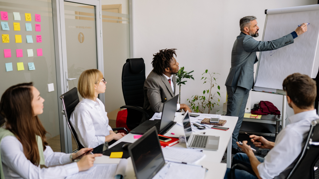 Finance professional leading a strategy meeting and presenting growth charts in a modern corporate office.